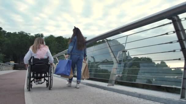 Disabled mom with daughter walking after shopping - Footage, Video