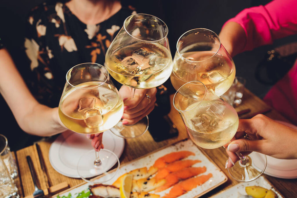 Close up shot of group of people clinking glasses with wine or champagne in front of bokeh background. older people hands. - Φωτογραφία, εικόνα