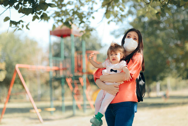 Mother Wearing Face Mask Child Keeping Child Away from Playground - 写真・画像