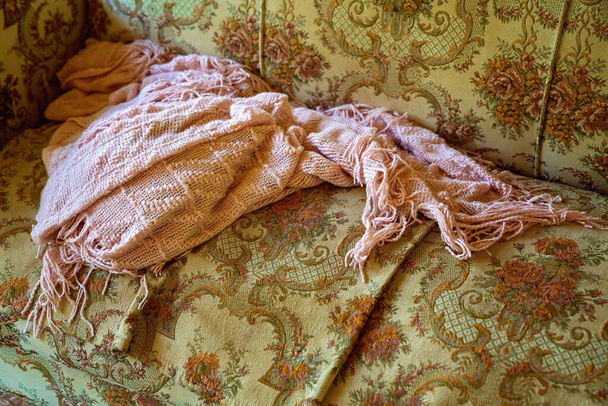 Древняя розовая шаль лежала брошенная на винтажном парчовом стуле из прошлых дней - Фото, изображение