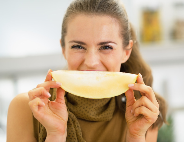 Young woman holding melon slice in front of mouth - Fotoğraf, Görsel