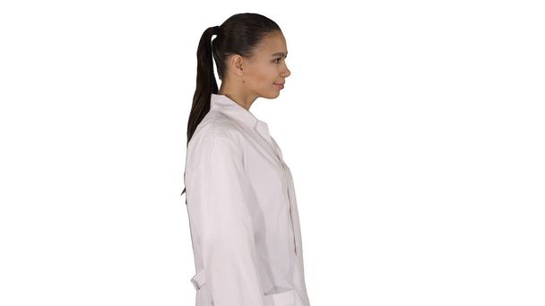 Doctor beautician in a white robe is walking on white background - Фото, зображення