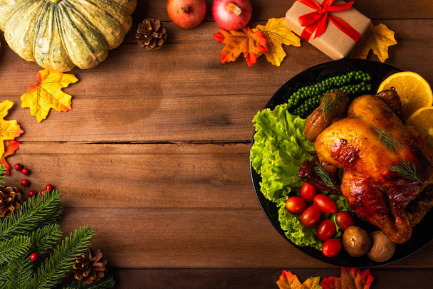 Thanksgiving roast turkey or chicken and vegetables, Top view Christmas dinner feast food decoration traditional homemade on wooden table background, Happy thanksgiving day of holiday concept - Foto, afbeelding