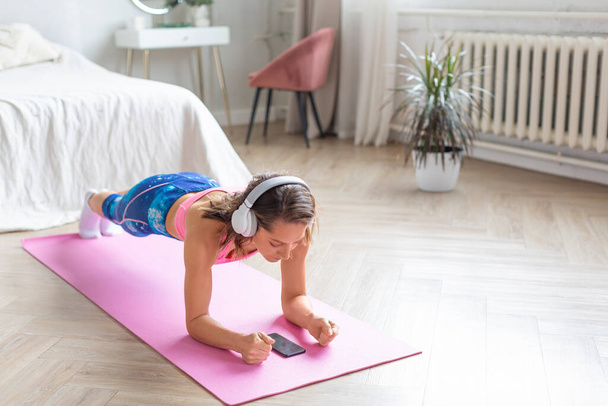 Woman working out at home. Plank position. - Photo, Image
