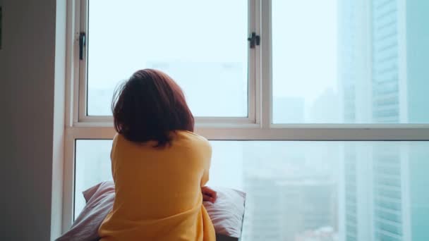 Mulher asiática sentada e olhando para fora depois de ser trancada. Sentindo-se sozinho e com saudades de casa, conceito ficar em casa - Filmagem, Vídeo