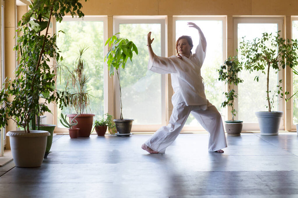 Young Woman praticing tai chi chuan in the gym. Chinese management skill Qi's energy. - Valokuva, kuva