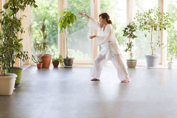 Young Woman praticing tai chi chuan in the gym. Chinese management skill Qi's energy. - Valokuva, kuva