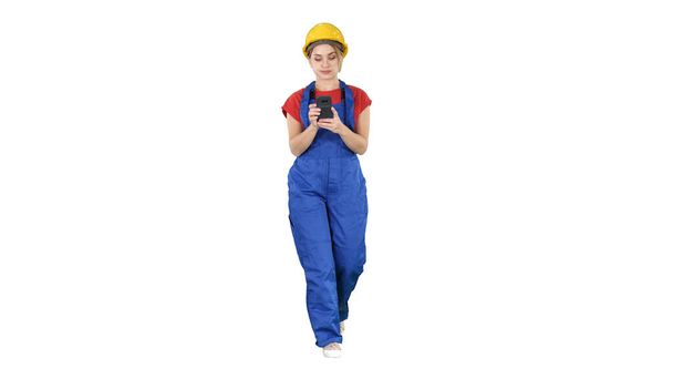 Female worker walking and using phone on white background. - Foto, Imagen