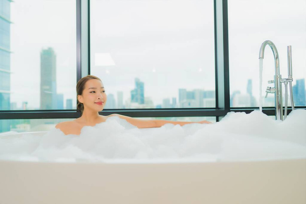 Портрет красивая молодая азиатская женщина расслабиться улыбка досуг в ванной комнате интерьер - Фото, изображение