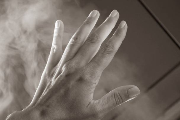 Open palm with five fingers in fume, filtered, sepia. Human arm in natural light with shadows, toned. Help gesture. Opacity concept. Woman hand in haze. Hand in the sky. - Photo, Image