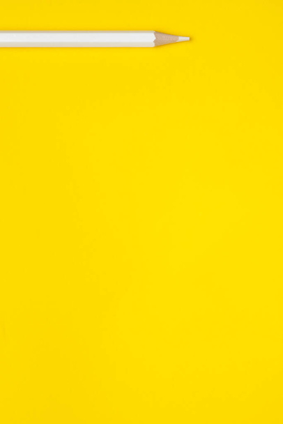 Vertical white sharp wooden pencil on a bright yellow background, isolated, copy space, mock up - Φωτογραφία, εικόνα
