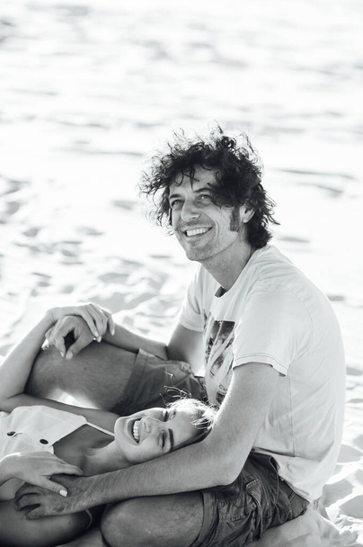 A curly-haired guy and a beautiful girl are having fun on the beach - Zdjęcie, obraz