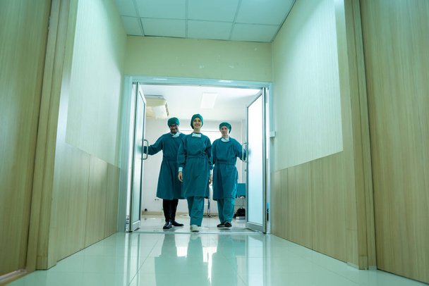 Group doctors walked out of the operating room and discussing after operation. - Photo, Image