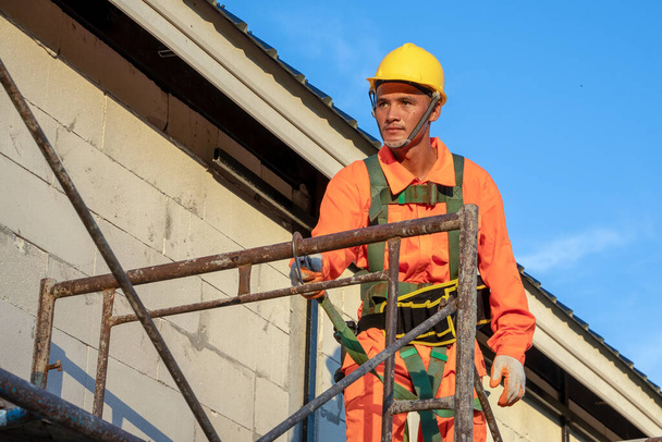 Bauarbeiter tragen Sicherheitsleine bei Arbeiten auf Baustelle. - Foto, Bild
