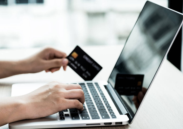 Biznesmen trzymać kartę kredytową do zakupów online na laptopie z domu, płatności e-commerce, bankowość internetowa, wydawanie pieniędzy na następne wakacje. - Zdjęcie, obraz