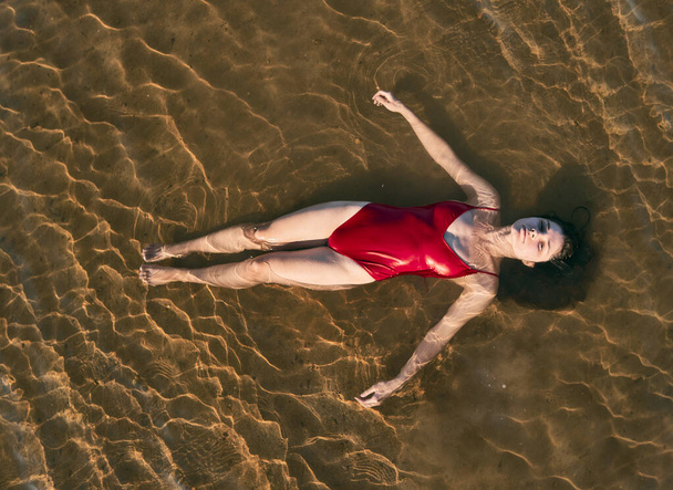 woman wears red swimsuit in the water top view - Photo, Image