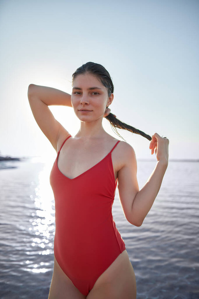 caucasian young girl in red swimsuit body looking at the camera. summer travel to the seaside - Fotoğraf, Görsel