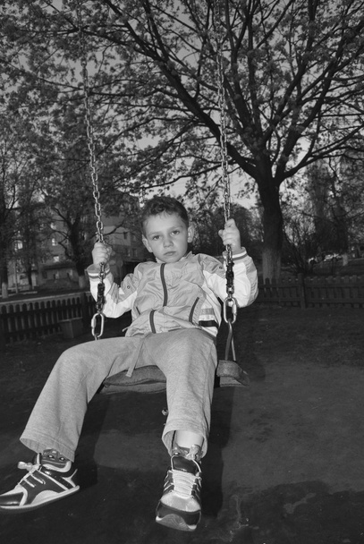 chico balanceándose en un columpio
 - Foto, imagen
