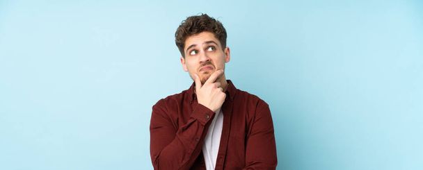 Young caucasian man isolated background having doubts - Foto, immagini