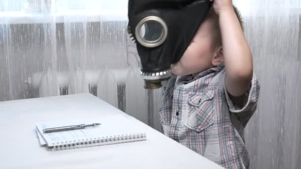pequeno menino caucasiano de cabelos curtos tenta usar máscara de gás, sua irmã ajuda-o - Filmagem, Vídeo