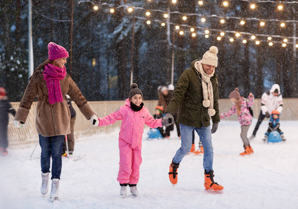 happy family at outdoor skating rink in winter - Fotoğraf, Görsel