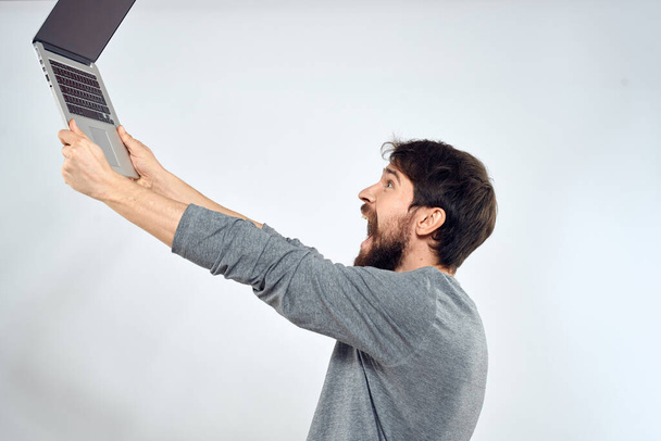 Hombre barbudo con portátil en las manos tecnología de comunicación por Internet fondo de luz - Foto, imagen