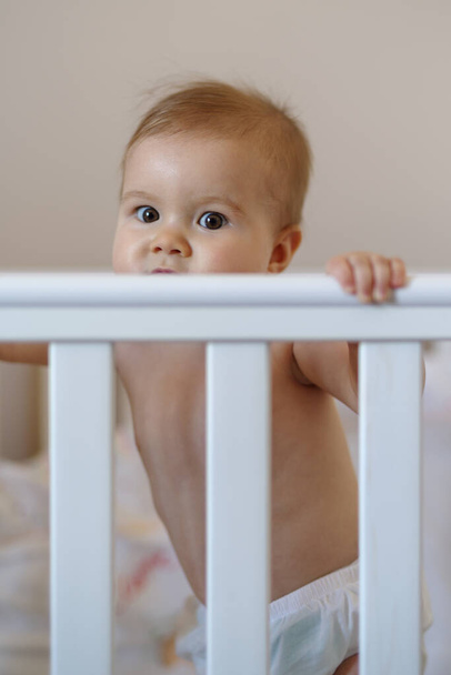 8-miesięczna dziewczynka stojąca w łóżeczku - Zdjęcie, obraz