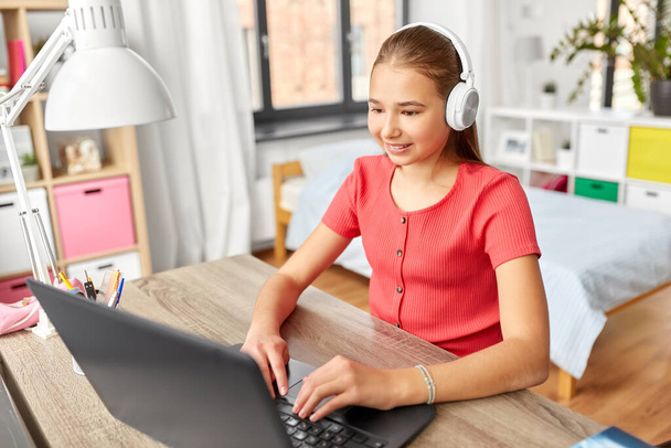 girl in headphones with laptop computer at home - Photo, Image