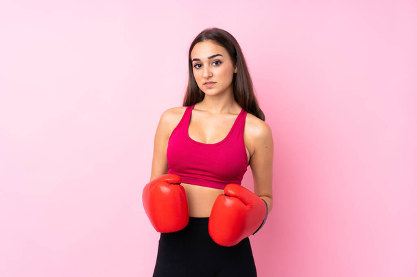 Nuori urheilu tyttö yli eristetty vaaleanpunainen tausta nyrkkeilyhanskat - Valokuva, kuva