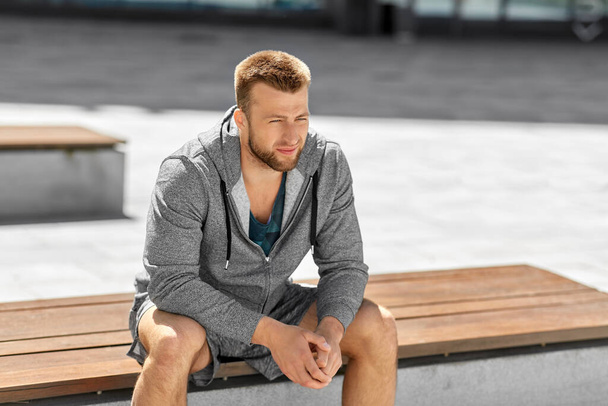 young man sitting on bench outdoors - Photo, image