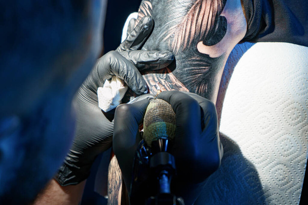 Imagen de tatuador haciendo tatuaje negro de serpiente para mujer - Foto, Imagen
