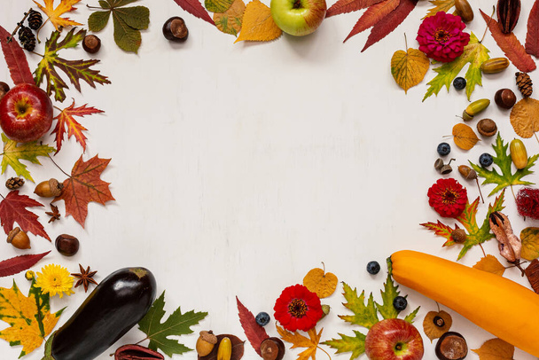秋の構図。乾燥した葉、リンゴ、スカッシュ、ナス、花、白い背景の果実。秋、秋、グリーティングカード、感謝祭の日のコンセプト。フラットレイアウト、トップビュー、テキストのコピースペース - 写真・画像