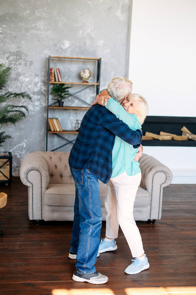 Romantic modern senior couple hagging indoors - Foto, imagen