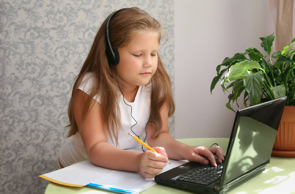 Keskittynyt lapsi itse eristäminen yllään kuulokkeet kannettavan tietokoneen kahvilassa, kirjoittaa muistiinpanoja, opiskelija tyttö oppimisen kieli, katsella verkossa webinar, Kotikoulutus, verkko-oppimisen käsite - Valokuva, kuva