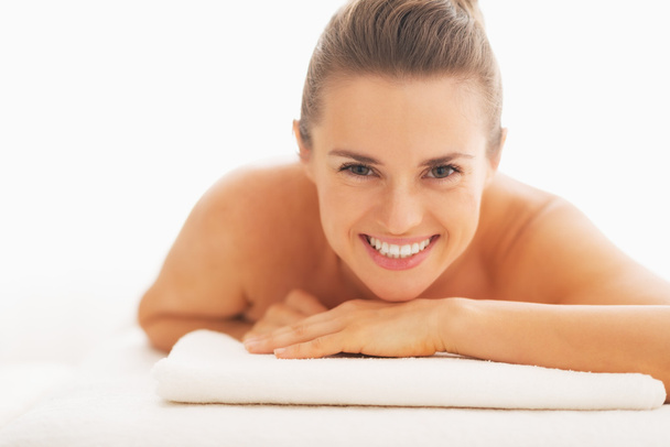 Portrait of smiling young woman laying on massage table - Foto, immagini
