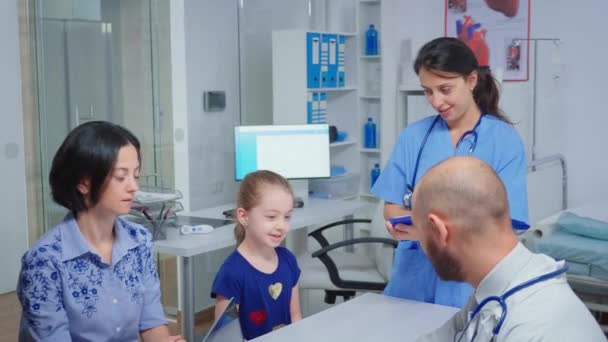 Lekarz i pielęgniarka rozmawiają z pacjentem dziecka - Materiał filmowy, wideo