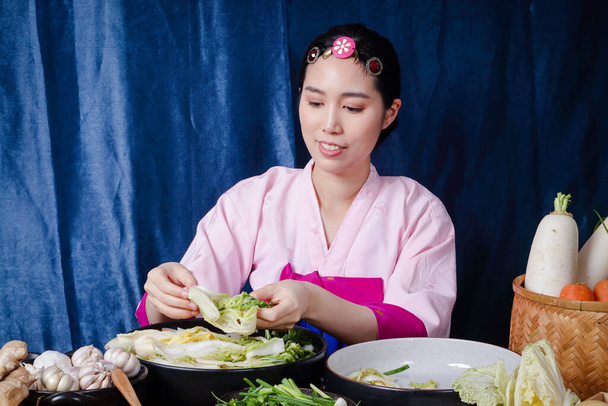 Корейские женщины носят традиционные ханбоксы, готовят кимчи. концепция приготовления бродильных продуктов, которые являются очаровательными и ароматные, азиатская кухня из народной мудрости - Фото, изображение