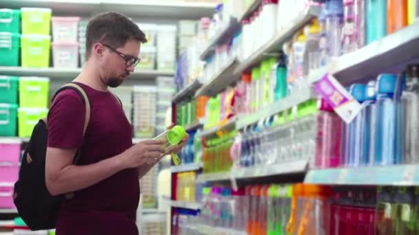 Mladý muž kupuje nádobu na vodu v supermarketu - Záběry, video