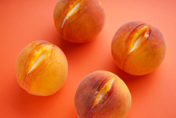 Juyci pêssegos em um fundo laranja. Conceito de sexo - Foto, Imagem