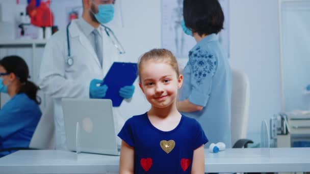 Portret dziewczynki uśmiechniętej w gabinecie lekarskim - Materiał filmowy, wideo