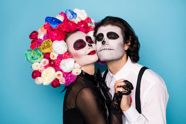 Profile photo of charming creepy romantic couple man lady hold hands meet after lifelong parting wear black dress death costume roses headband suspenders isolated blue color background - Fotografie, Obrázek