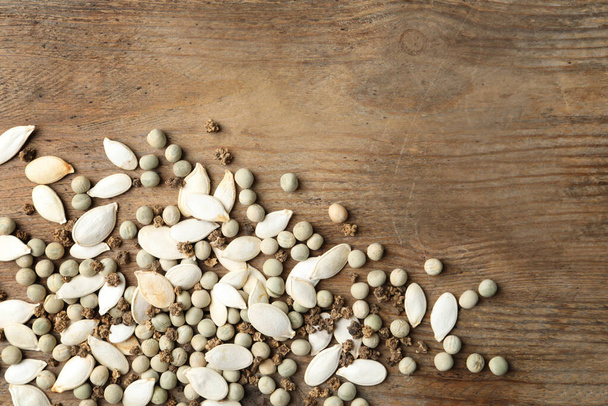 Mixed vegetable seeds on wooden background, flat lay. Space for text - Foto, Bild