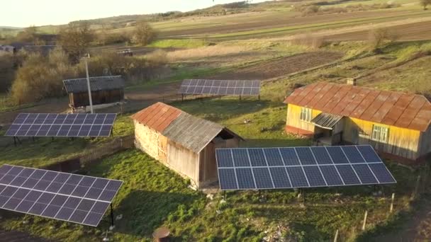Zicht vanuit de lucht op zonnepanelen in groene landelijke dorpswerf. - Video