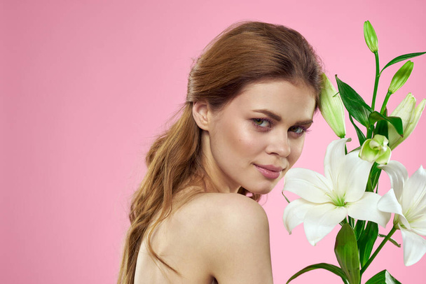 Pretty woman holding bouquet of flowers in hands bare shoulders pink background charm - Photo, Image