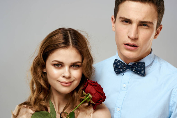 Fiatal pár romantika ölelés kapcsolat társkereső piros rózsa fény stúdió háttér - Fotó, kép
