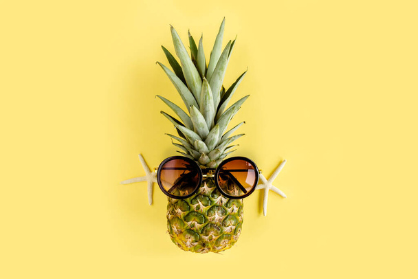 Hipster pineapple in sunglasses on yellow background. Summer background. Flat lay - Fotografie, Obrázek