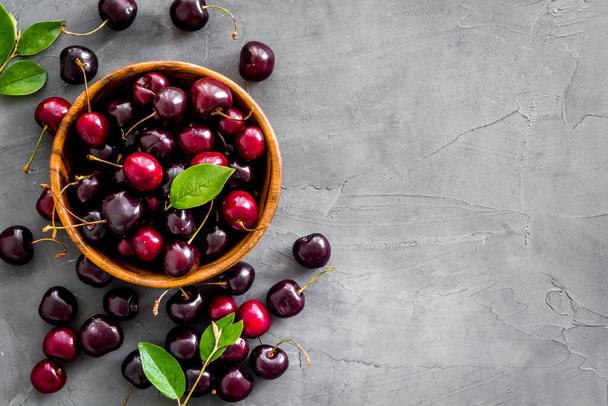Red cherries with leaves in wooden bowl. Layout, berries background - Foto, immagini