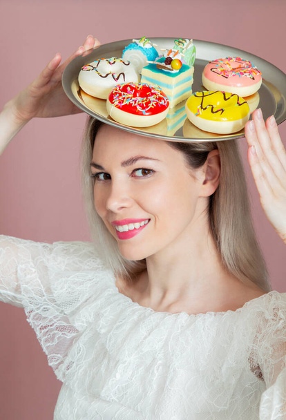beautiful girl offers a variety of sweets on a tray offers to buy, large selection, diet and proper nutrition - Zdjęcie, obraz