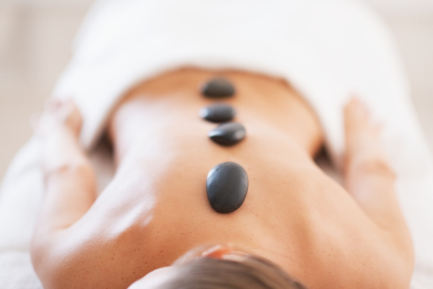 Closeup on relaxed young woman receiving hot stone massage - Photo, image