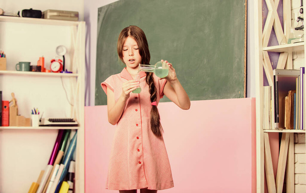 Young confident scientist. school laboratory. back to school. biology education. science lesson. small girl pupil with chemical flask. Use new technology. girl in chemistry class with testing tube - Foto, imagen